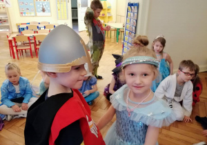 dziewczynka przebrana za księżniczkę i chłopiec za rycerza tańczą na balu karnawałowym