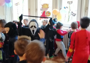 grupa dzieci przebrane w stroje karnawałowe tańczą na balu