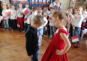 chłopiec i dziewczynka tańczą