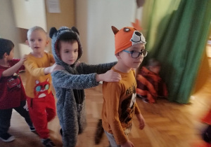 dzieci przebrane w stroje zwierzątek leśnych tańczą w wężyku