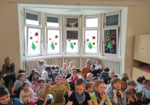 grupa dzieci siedzi na sali