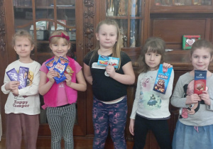 dziewczynki z grupy 3 pozują do zdjęcia z tabliczkami czekolady