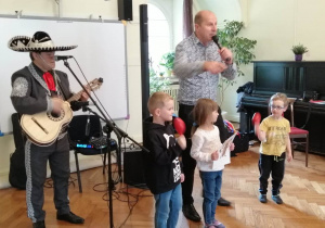 Pan Maciej i Pan Rafael wspólnie z trójką dzieci śpiewają i grają La Bambe