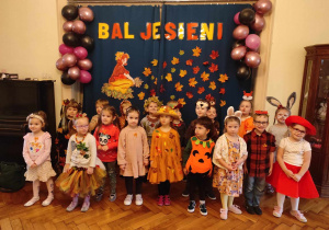 Dzieci z grupy 2 pozują do zdjęcia pod napisem bal jesieni