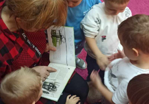 Dzieci z grupy 1 oglądają obrazki czytanej bajki przez mamę Rozalki
