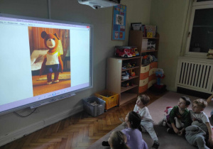 Dzieci z grupy 2 rozwiązują zagadki na tablicy multimedialnej