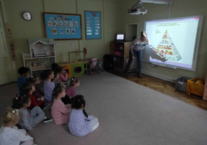 Dzieci z grupy 2 słuchają Pani Marty opisującej piramidę zdrowego żywienia