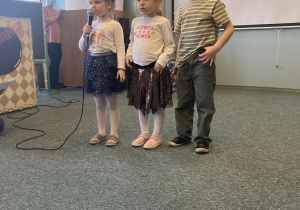 2 dziewczynki i chłopiec z grupy 3 mówią wierszyk dla seniorów