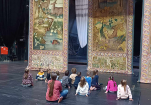 Grupa 4 na deskach teatru obserwuje dekorację do przedstawienia