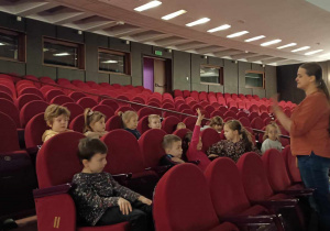Grupa 4 pozuje do zdjęcia na fotelach teatru