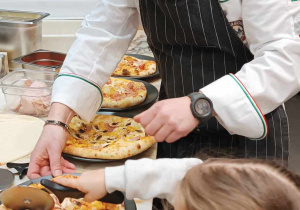 Kucharz pokazujący dzieciom jak robić pizzę