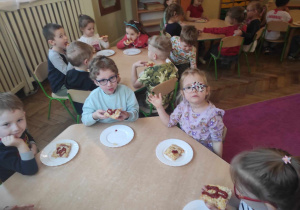 Dzieci z grupy 2 jedzące pizzę zrobiną przez siebie