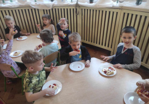 Dzieci z grupy 2 jedzące pizzę zrobiną przez siebie