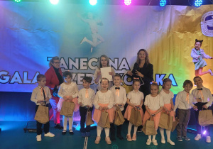 Dzieci z grupy tanecznej "Żaczki" pozują do zdjęcia na gali z Panią Dyrektor i Panią Agnieszką Kowalską
