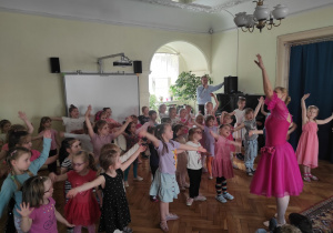 Tancerka uczy dzieci podstawowych kroków tanecznych "tańca kwiatów"