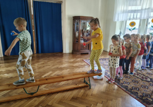 Chłopiec i dzieczynka z grupy 3 na ławeczce z kropką