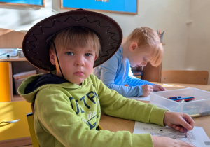 chłopiec siedzi przy stole