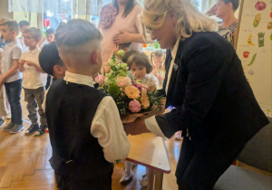 Absolwenci wręczający Pani Dyrektor kwiaty
